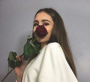chica con una flor de rosa roja sobre su cara
