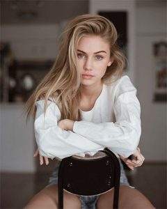 pose para fotos sentada en una silla desde casa