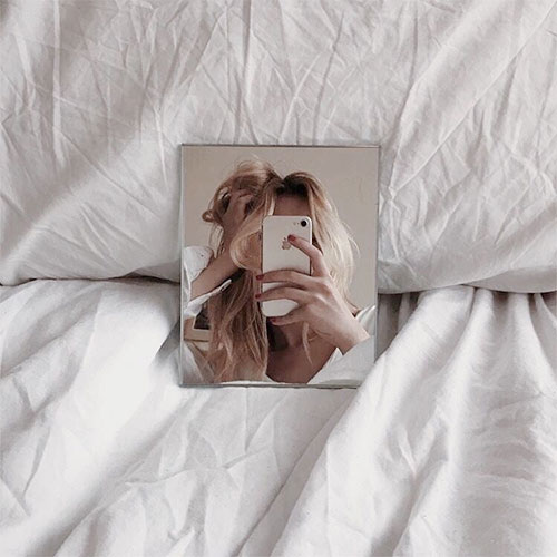 pose seflie espejo en la cama